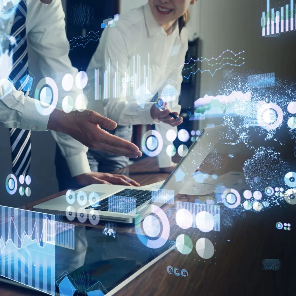 Business people at a table with data charts and dashboards overlaid on the photo
